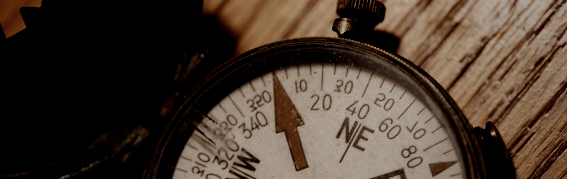 Antique Compass on wood floor represents dealer locator